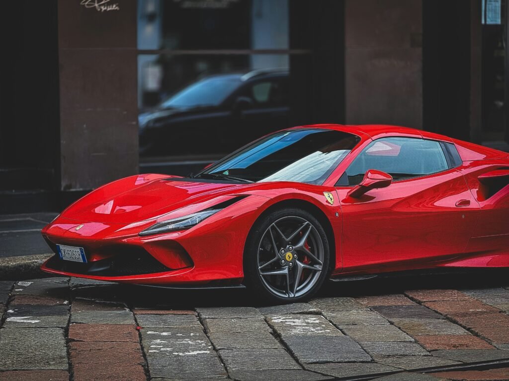 A red Ferrari car with glasses behind it 